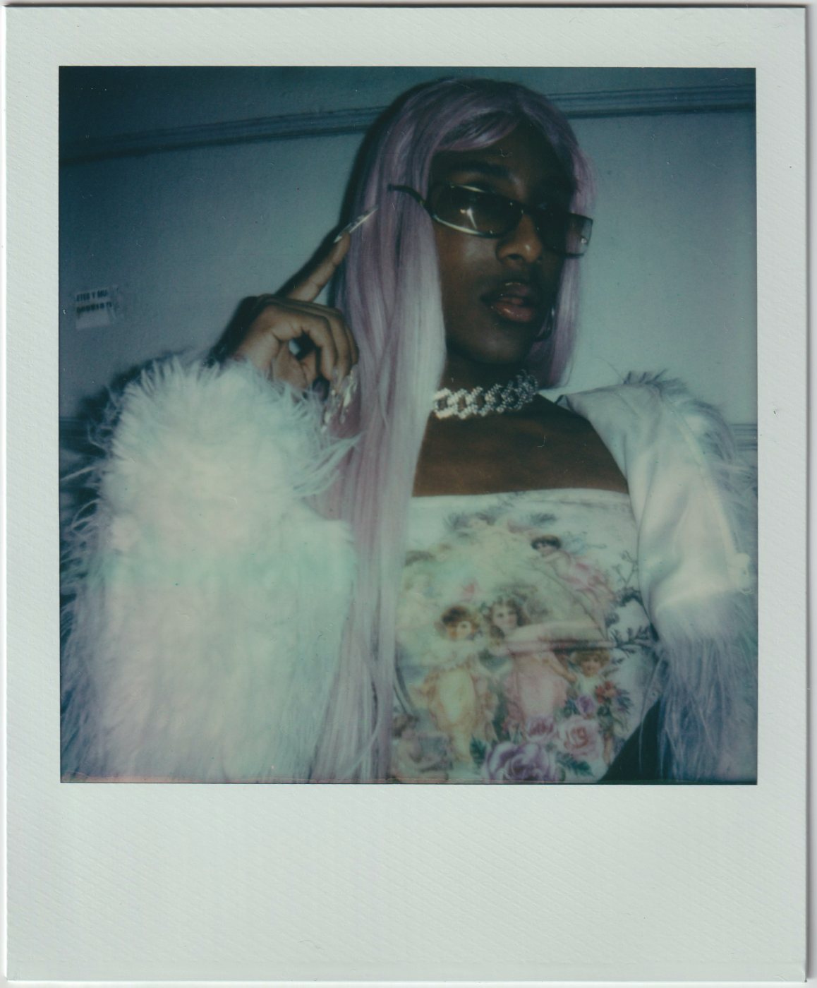 Person with a lilac wig, sunglasses and a white fur jacket