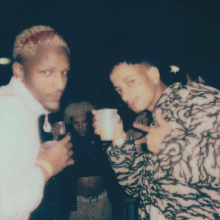Three people toasting with cups at night