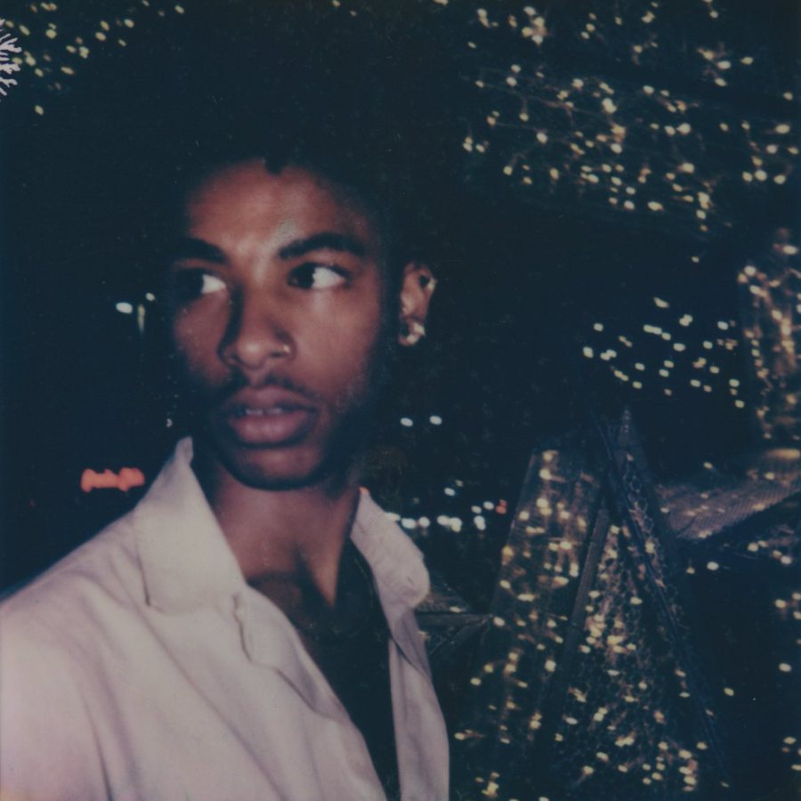 Portrait of a person at night before a wall of lights